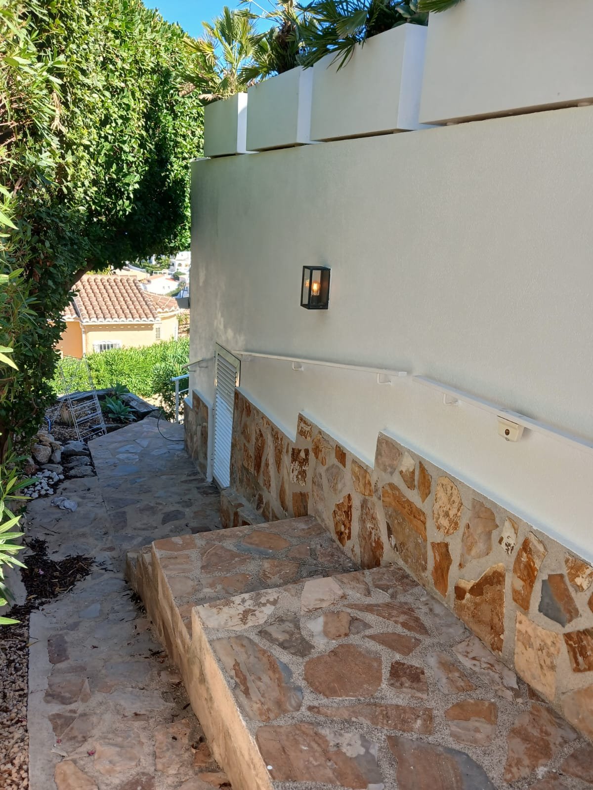 A finished exterior wall with stone steps leading up to it