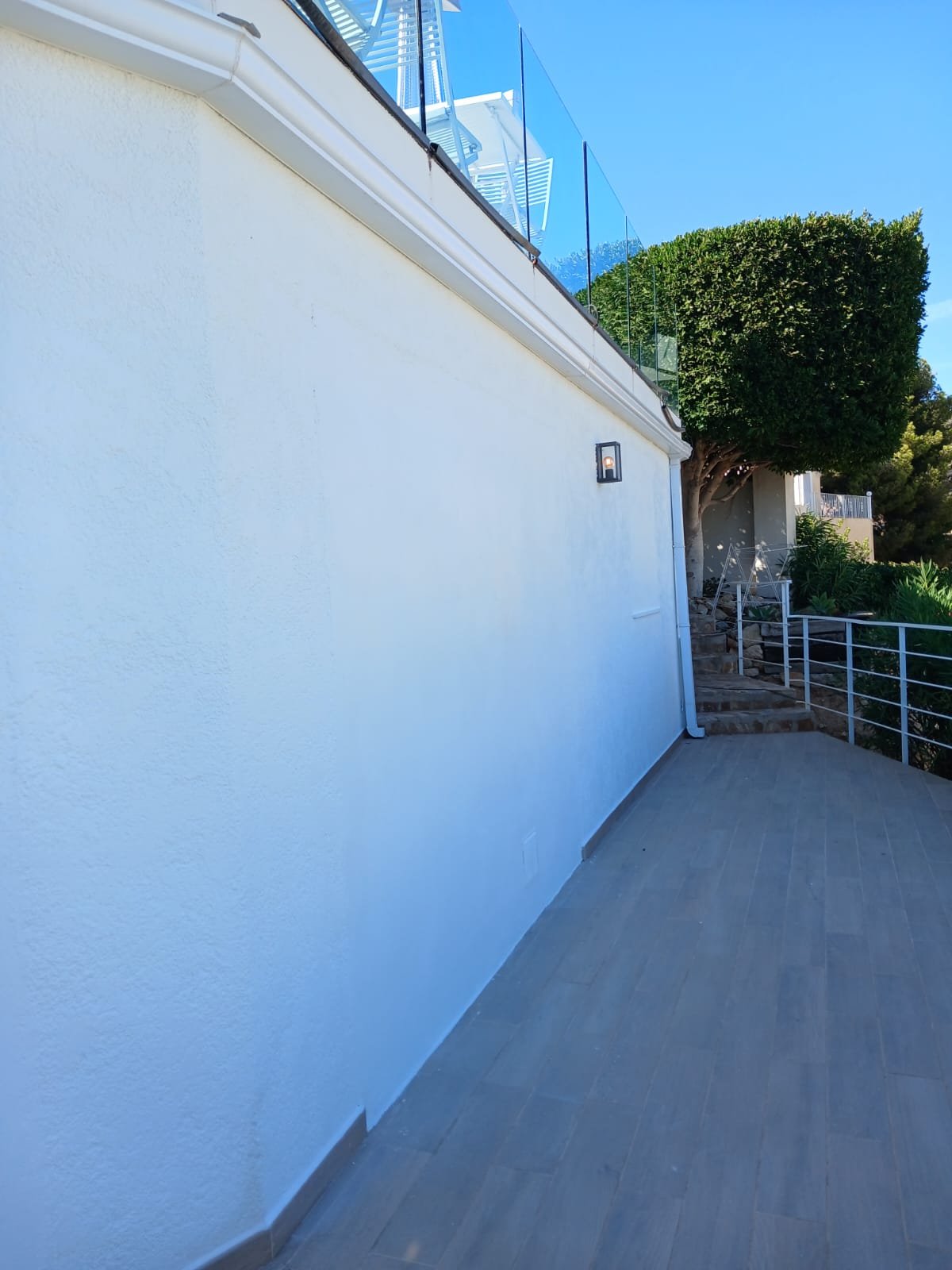 A freshly painted white exterior wall along a terrace